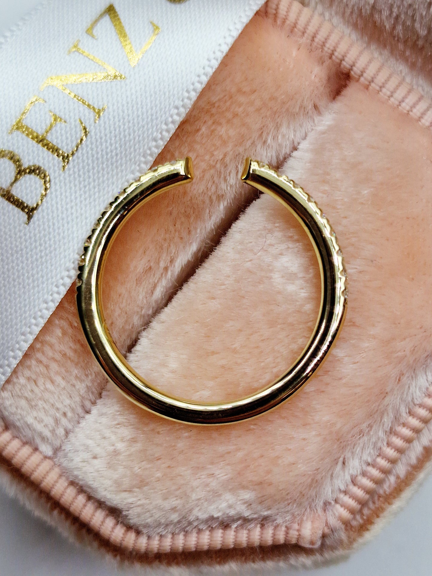 Gold ring with diamonds in a pink velvet box.