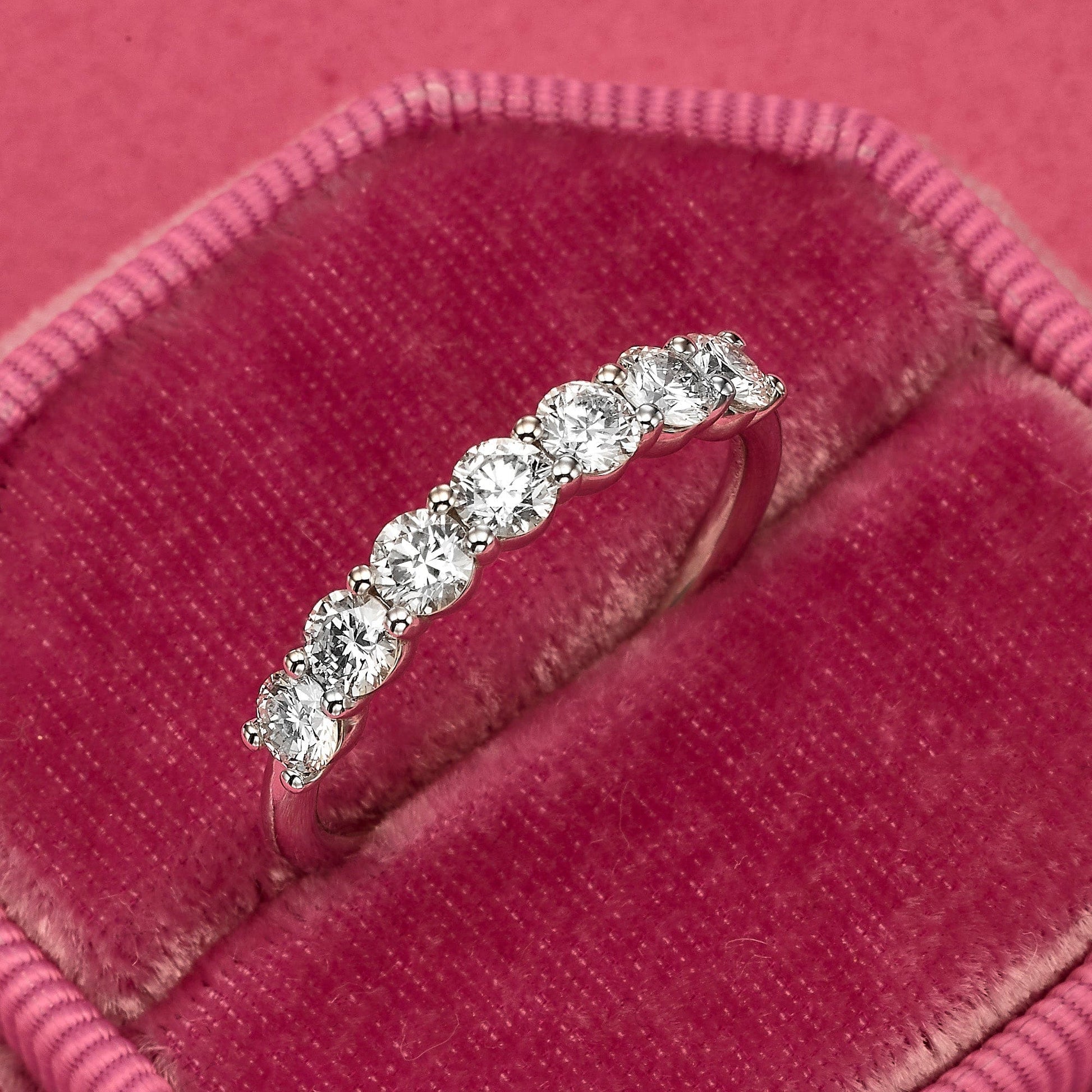 Diamond band ring in a pink velvet ring box.