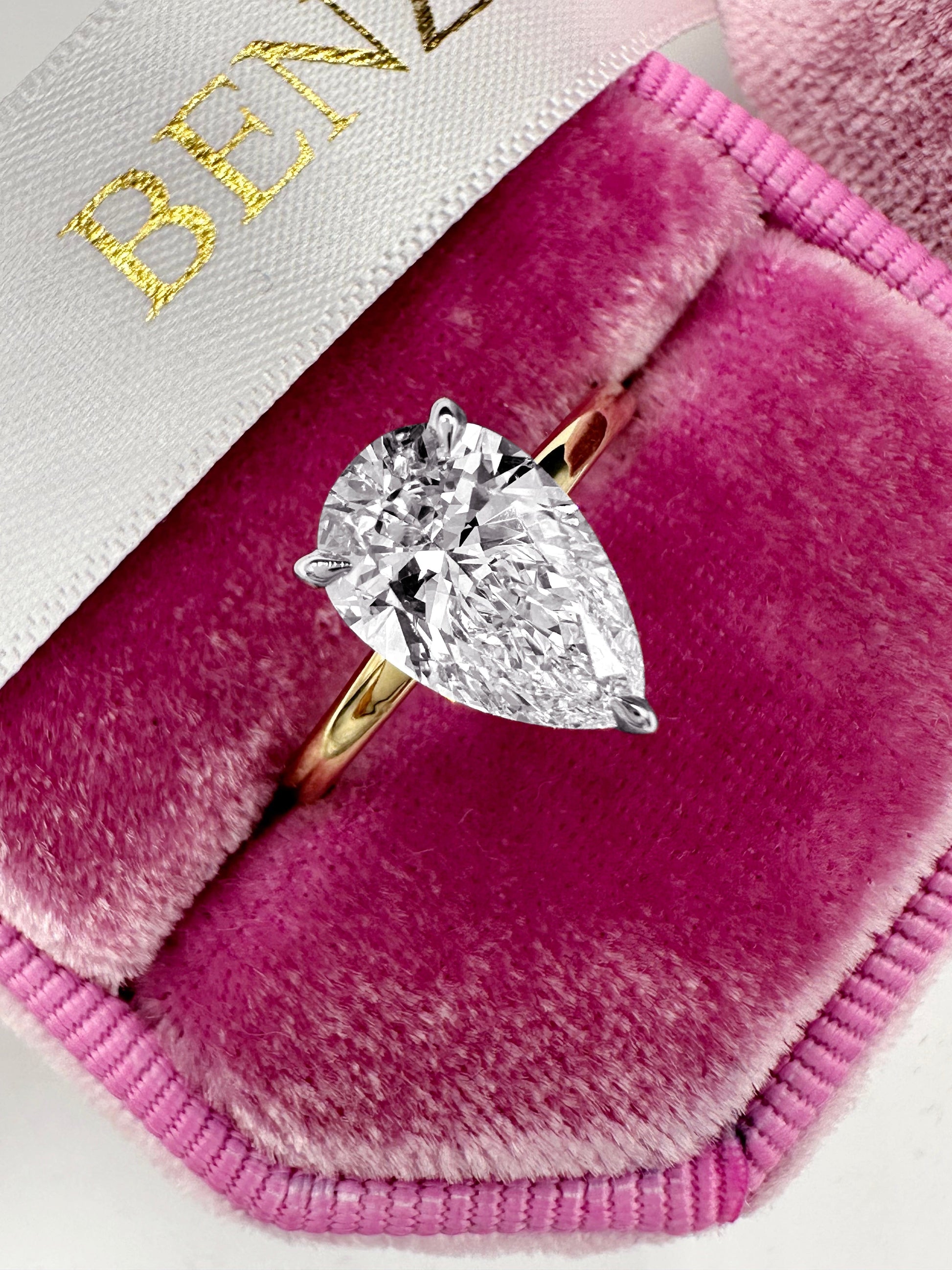 Pear-shaped diamond ring in a pink velvet box.