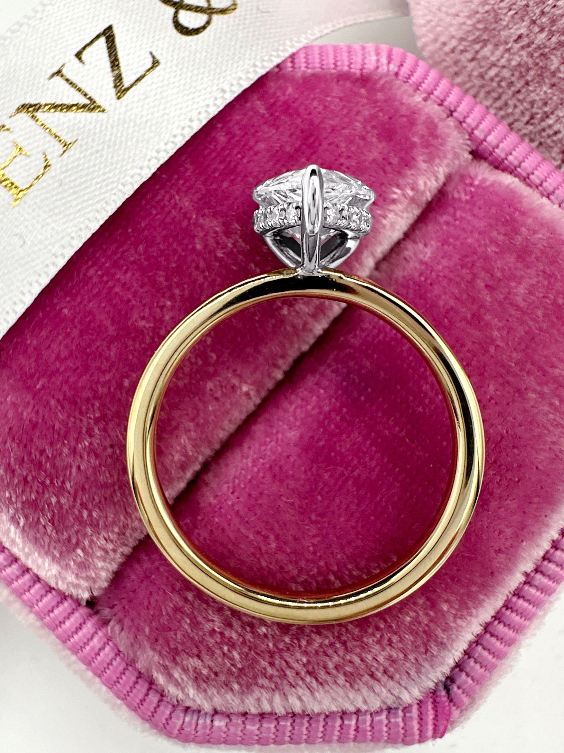 Diamond engagement ring on pink velvet.