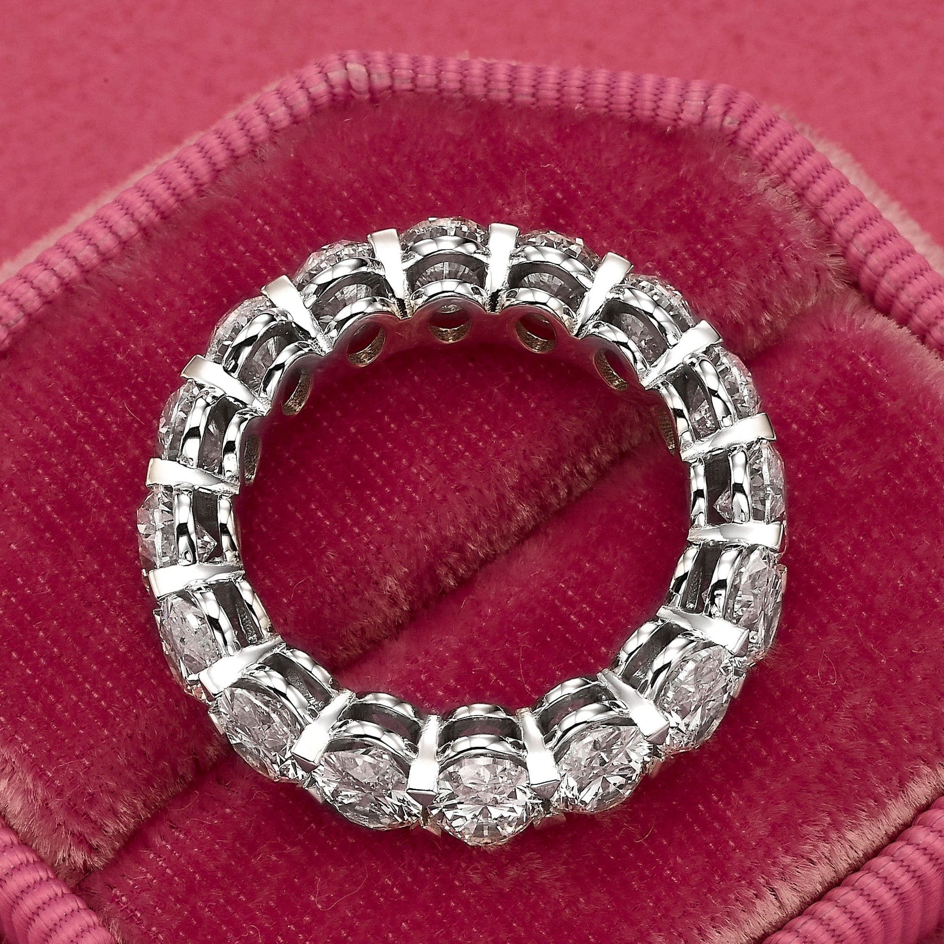 Diamond eternity ring on red velvet.