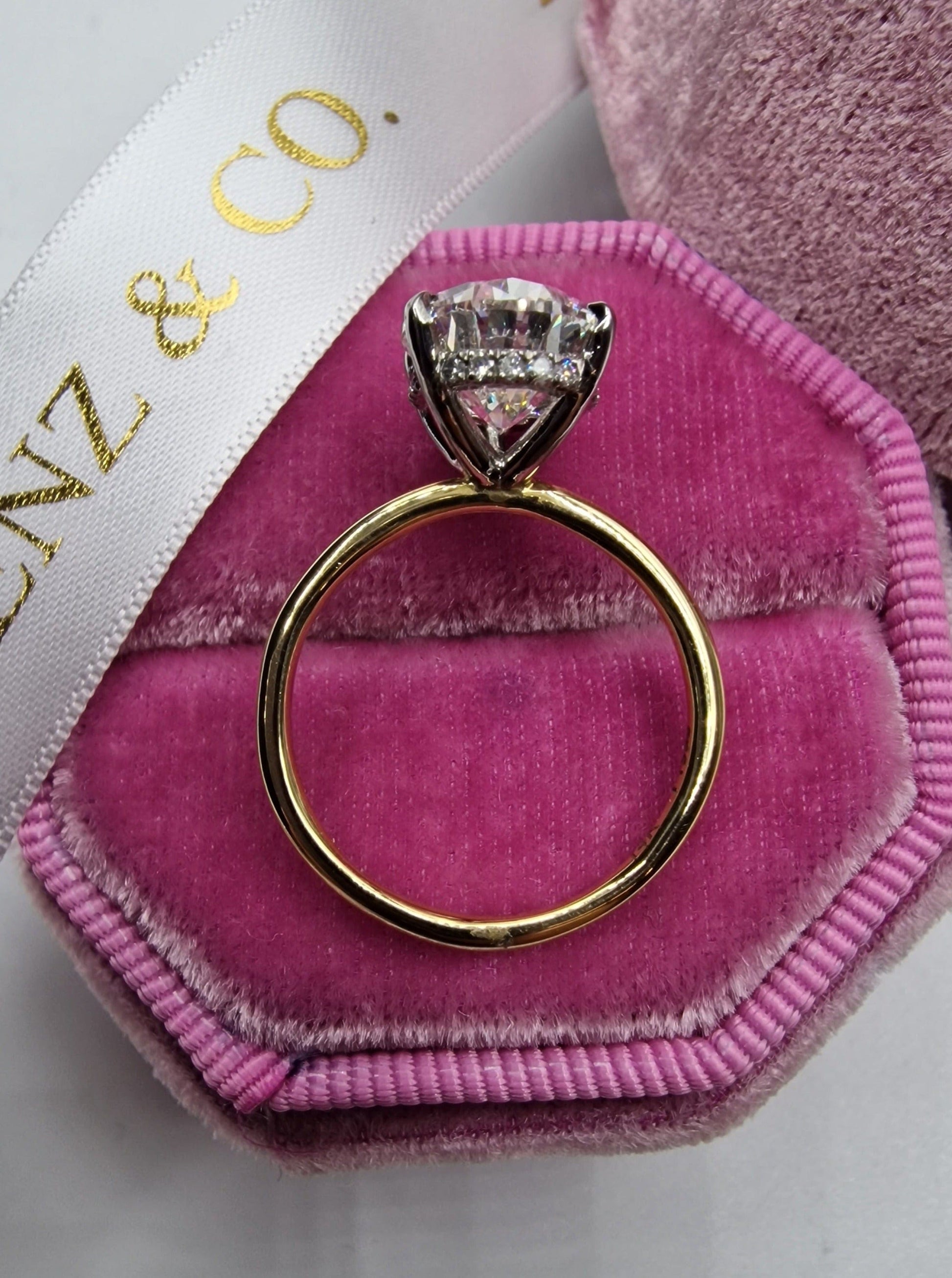 Diamond ring in a pink velvet ring box.