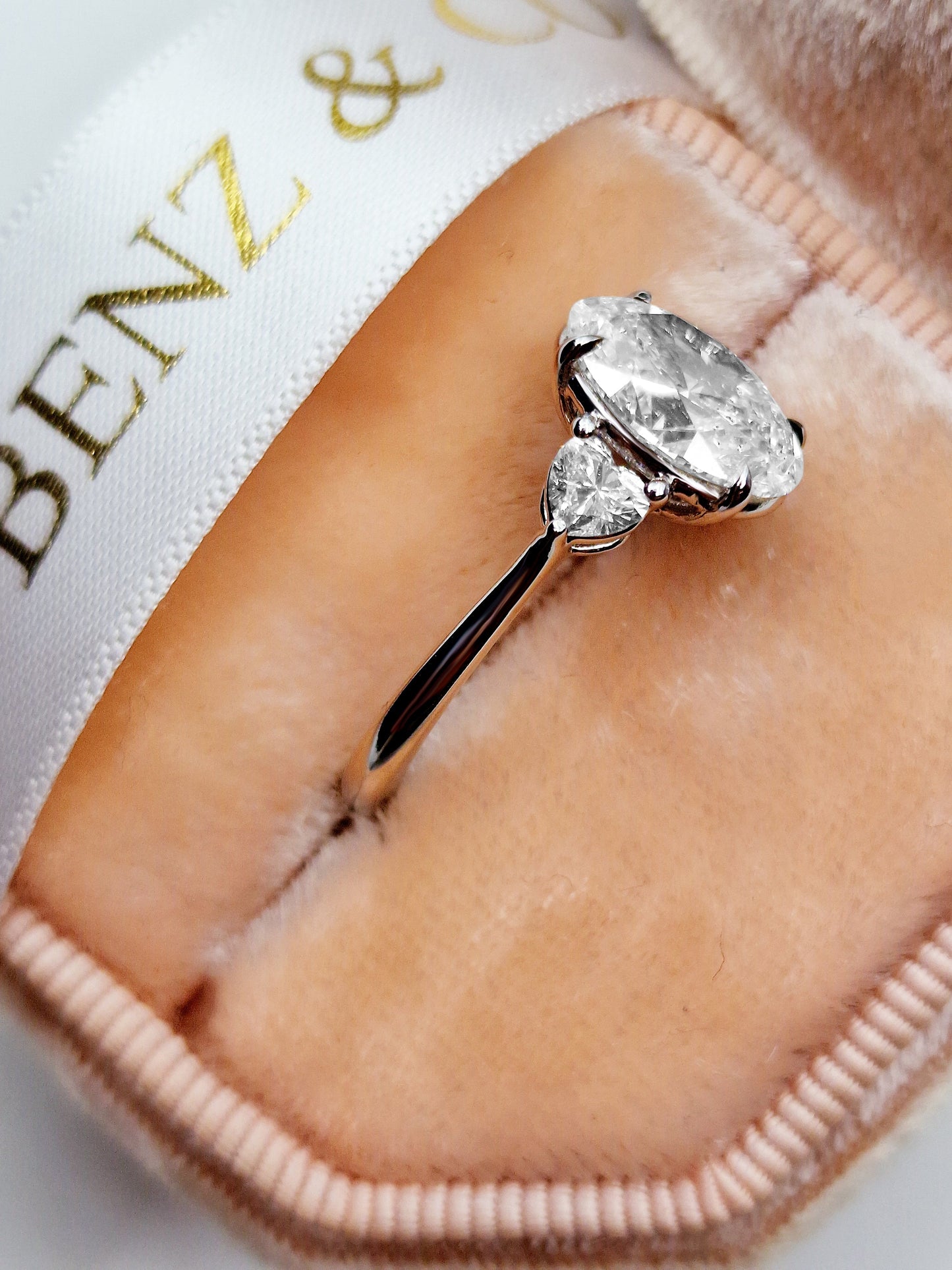 Diamond engagement ring in a pink jewelry box.