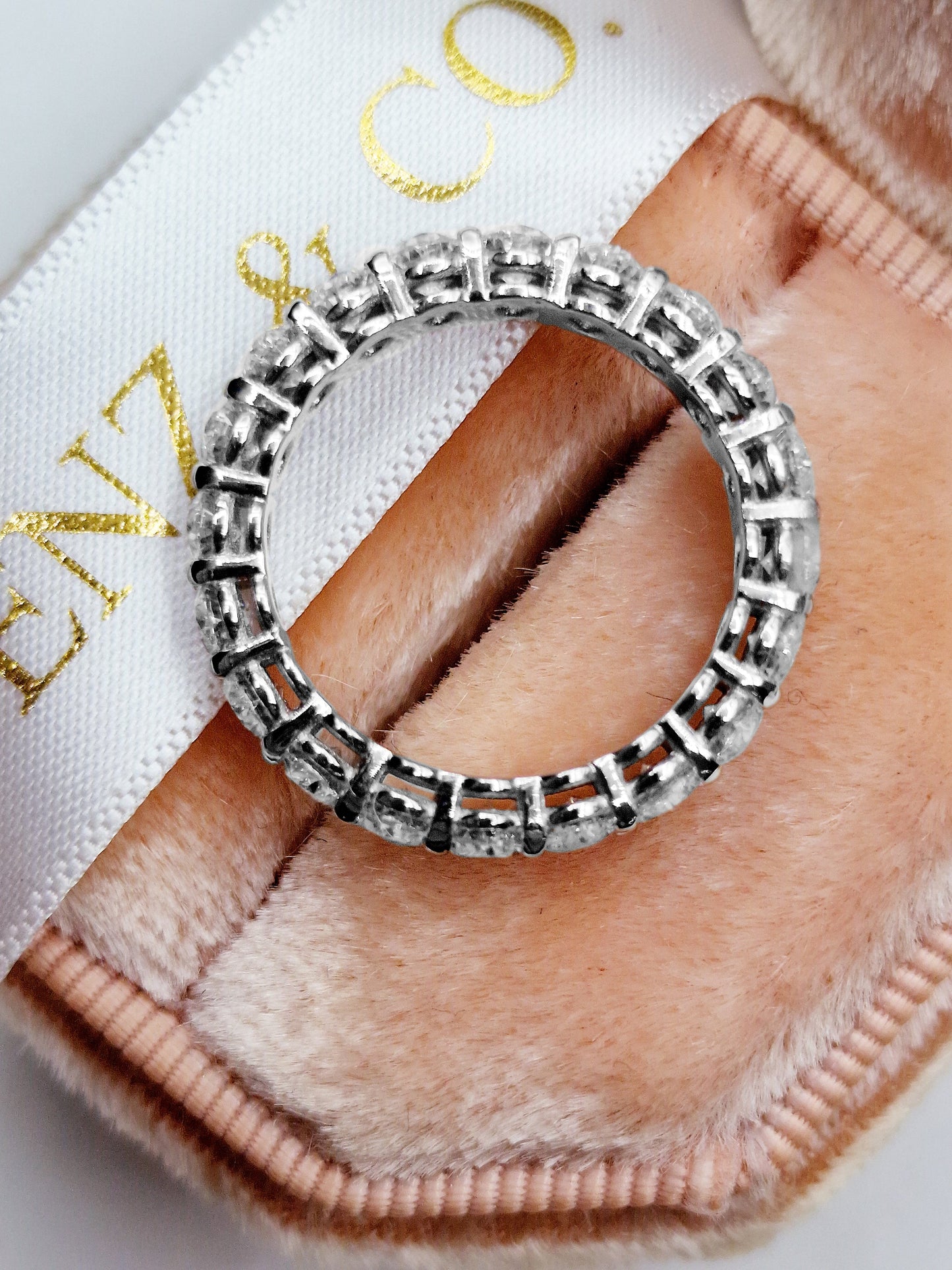 Diamond eternity ring in a pink ring box.
