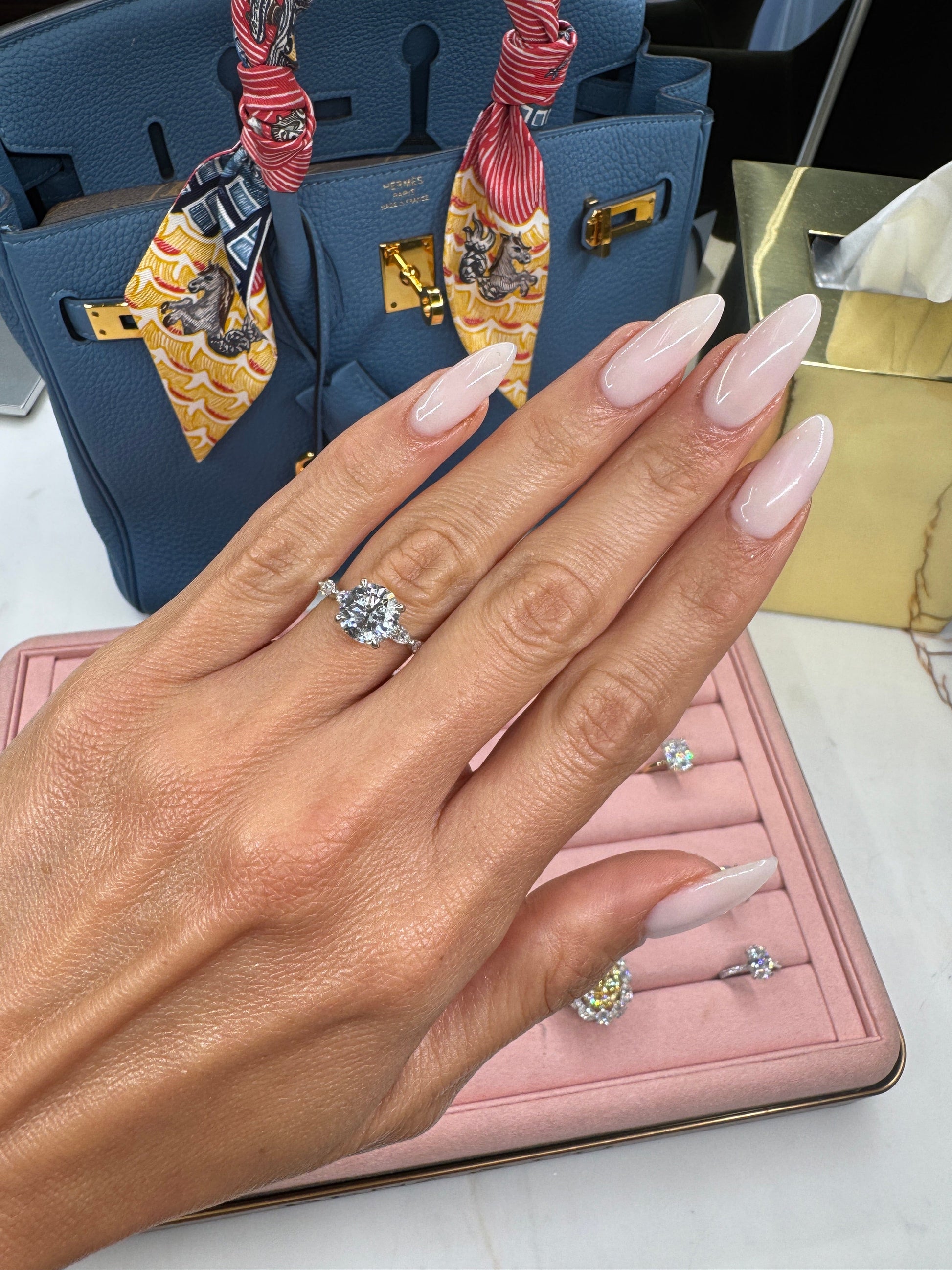 Woman's hand with 2ct round diamond engagement ring in 14k white gold.