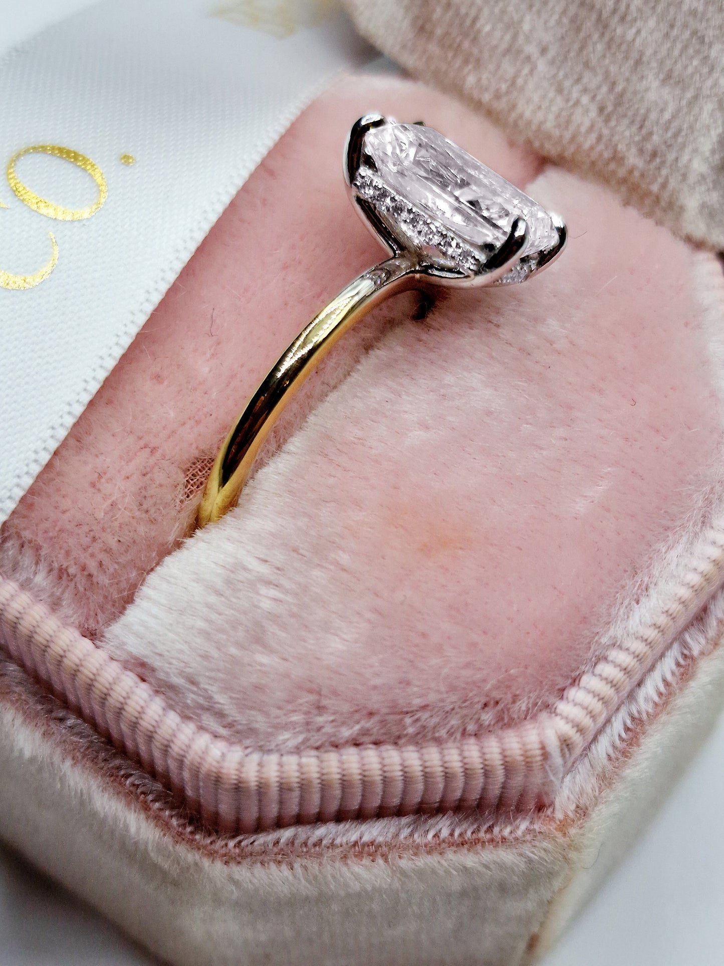 Diamond engagement ring in a pink jewelry box.