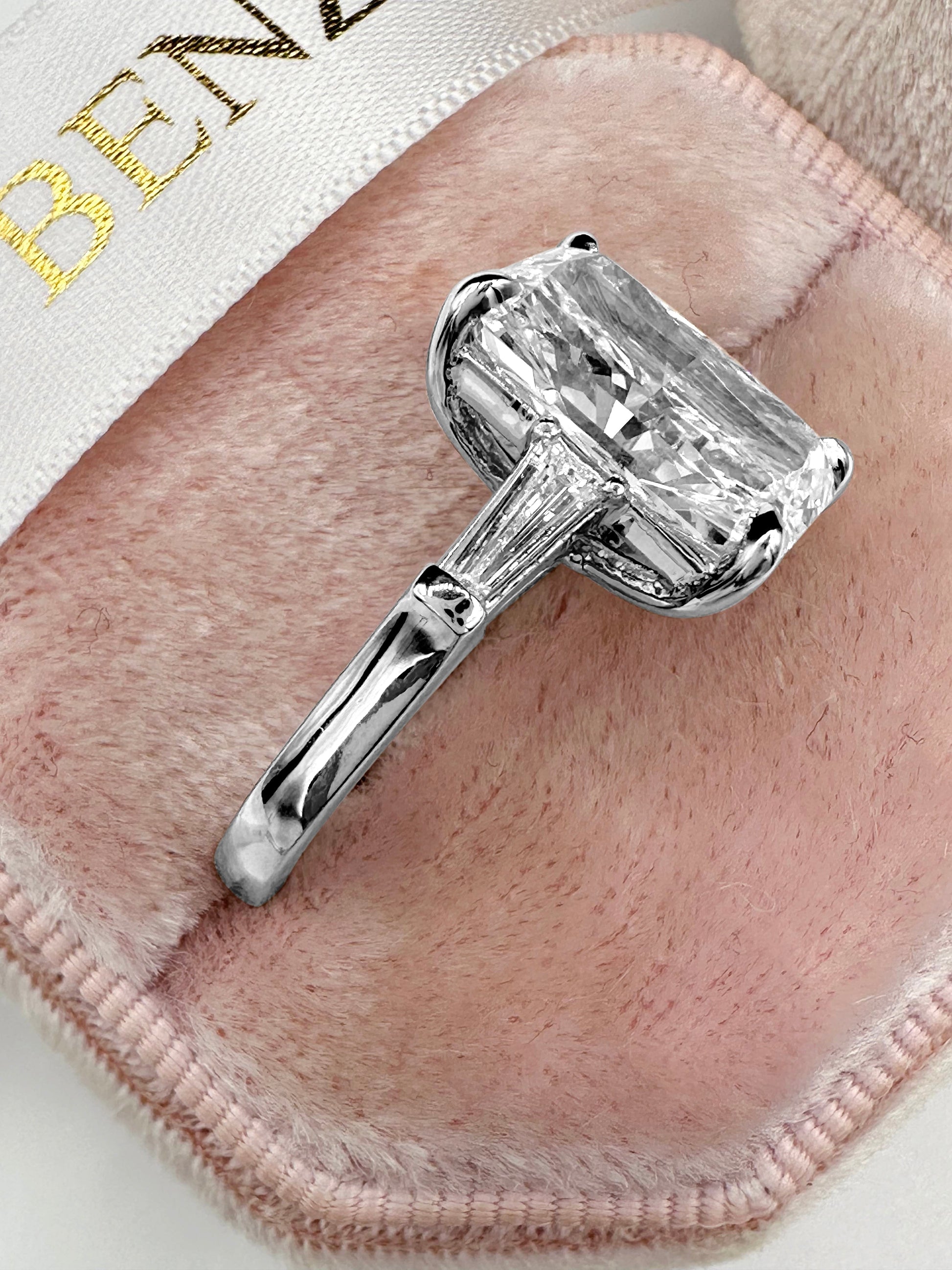 Elongated radiant cut diamond ring with tapered baguettes in platinum.
