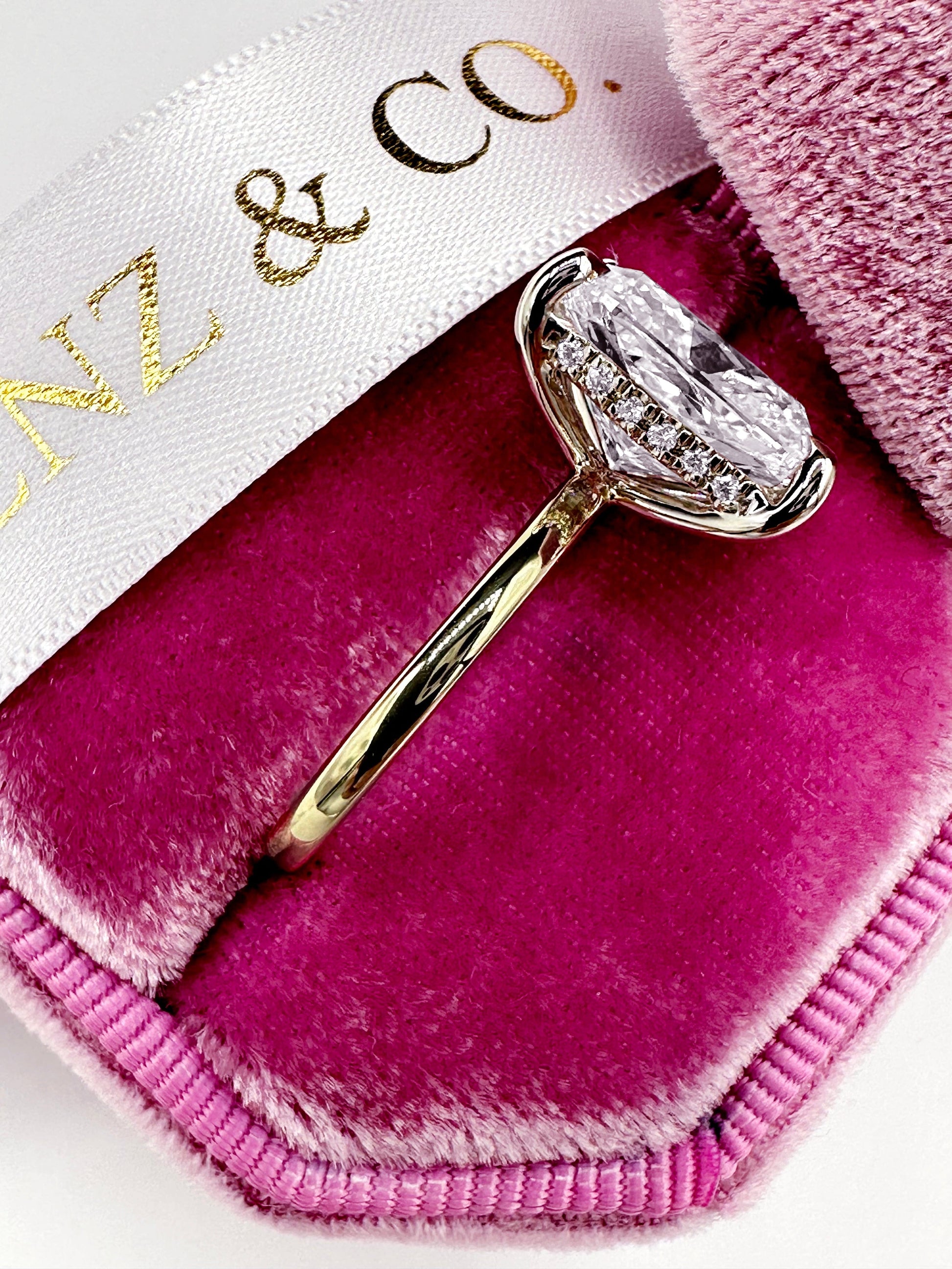 Diamond engagement ring in a pink velvet box.