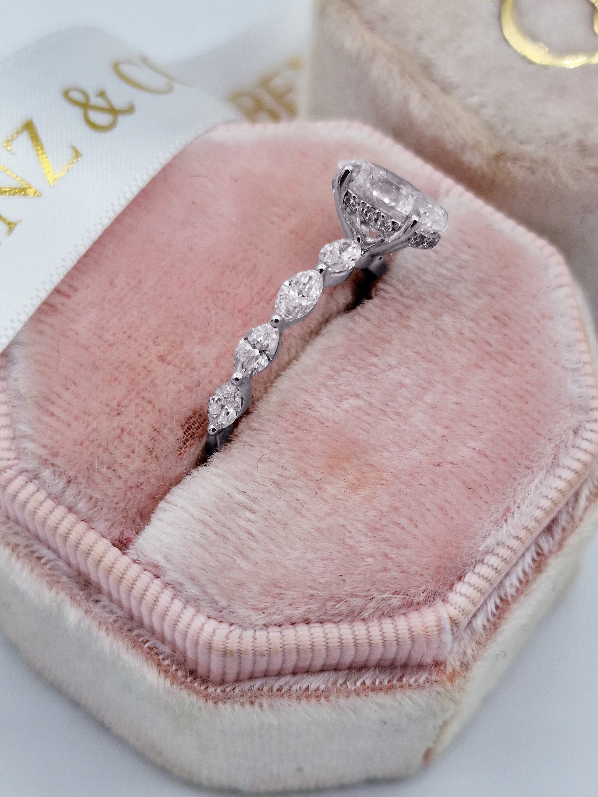 Oval diamond engagement ring with marquise cut side diamonds