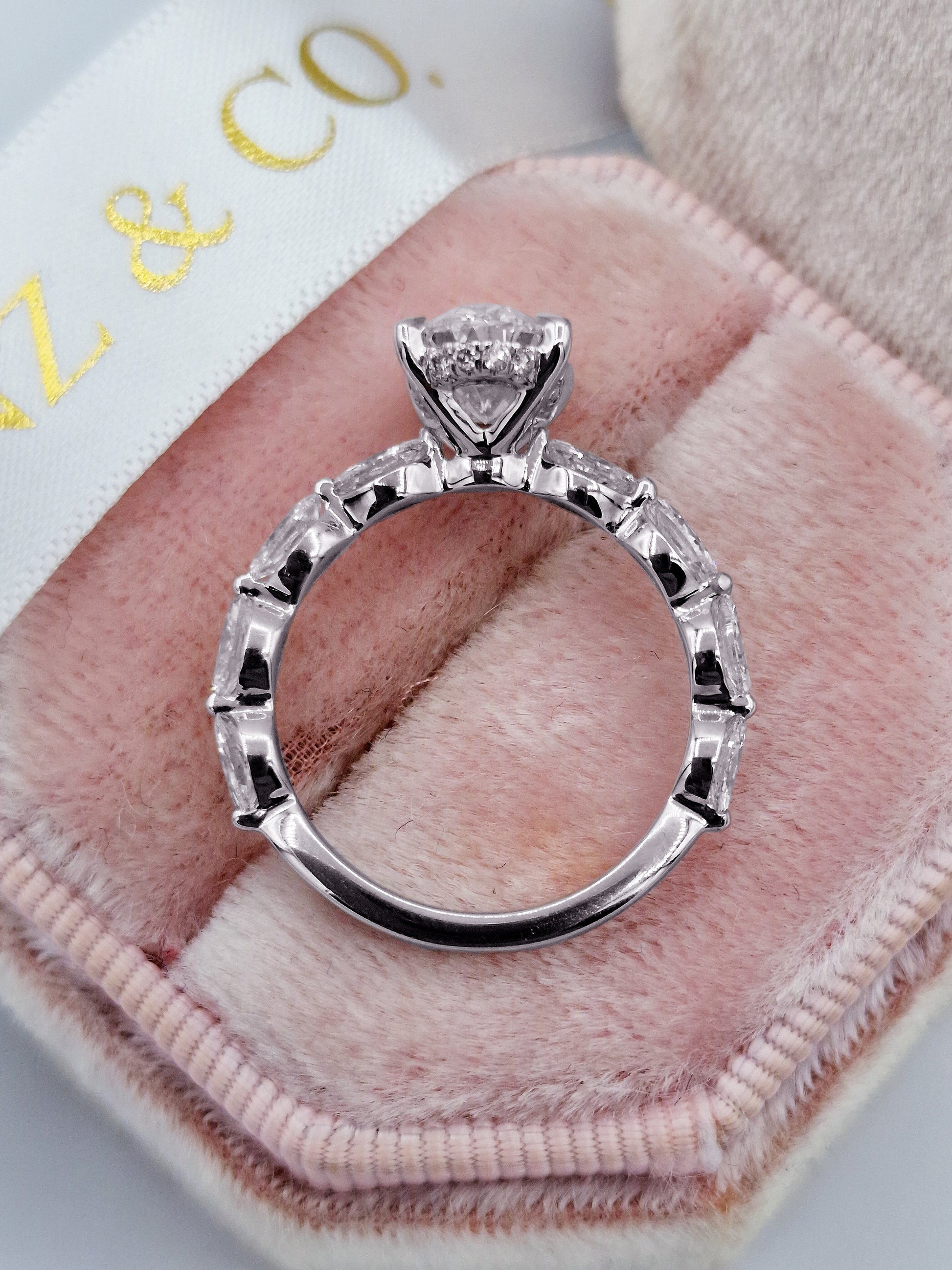Oval diamond engagement ring with marquise side stones in white gold