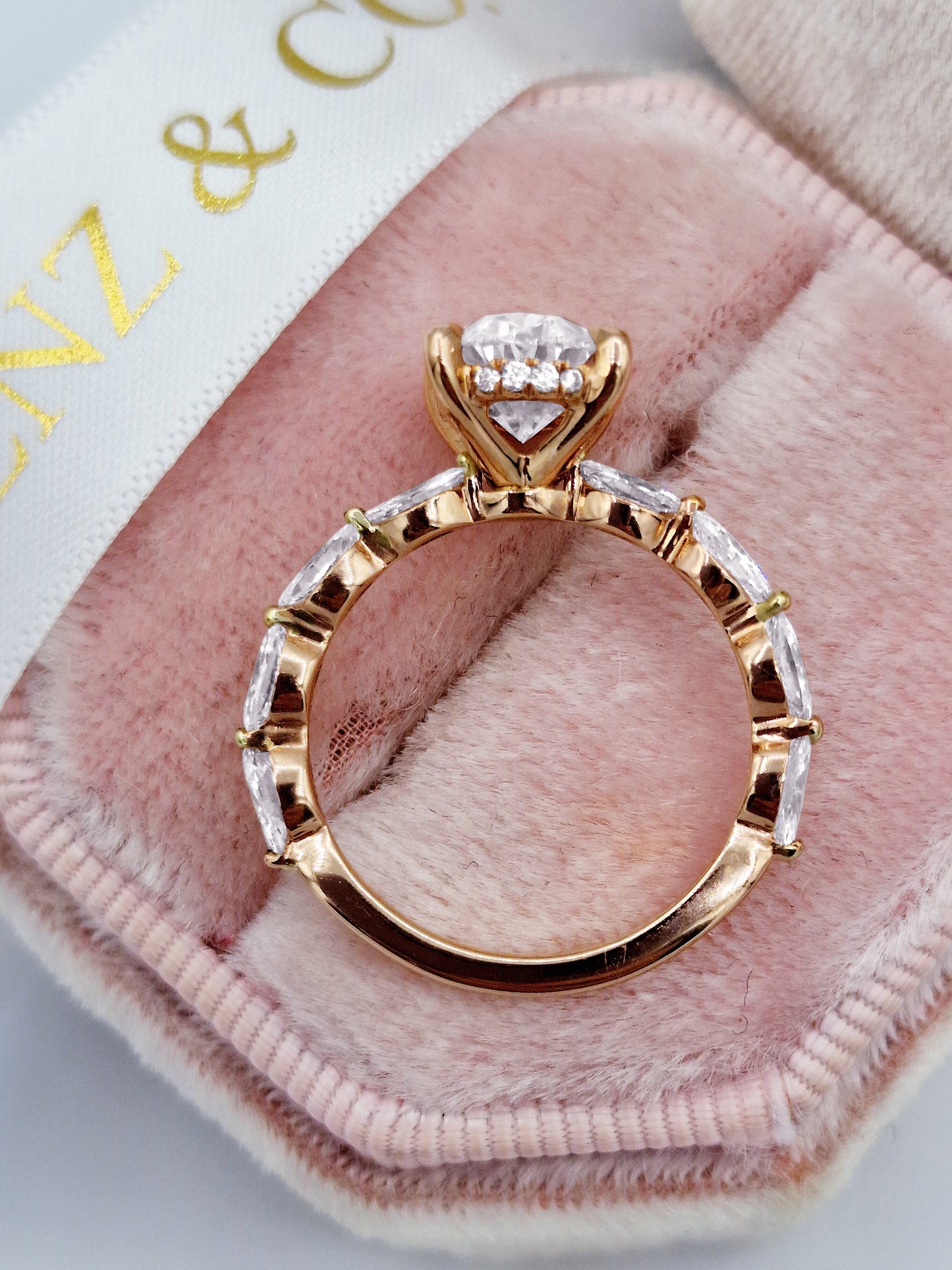 Rose gold oval diamond ring with marquise side stones