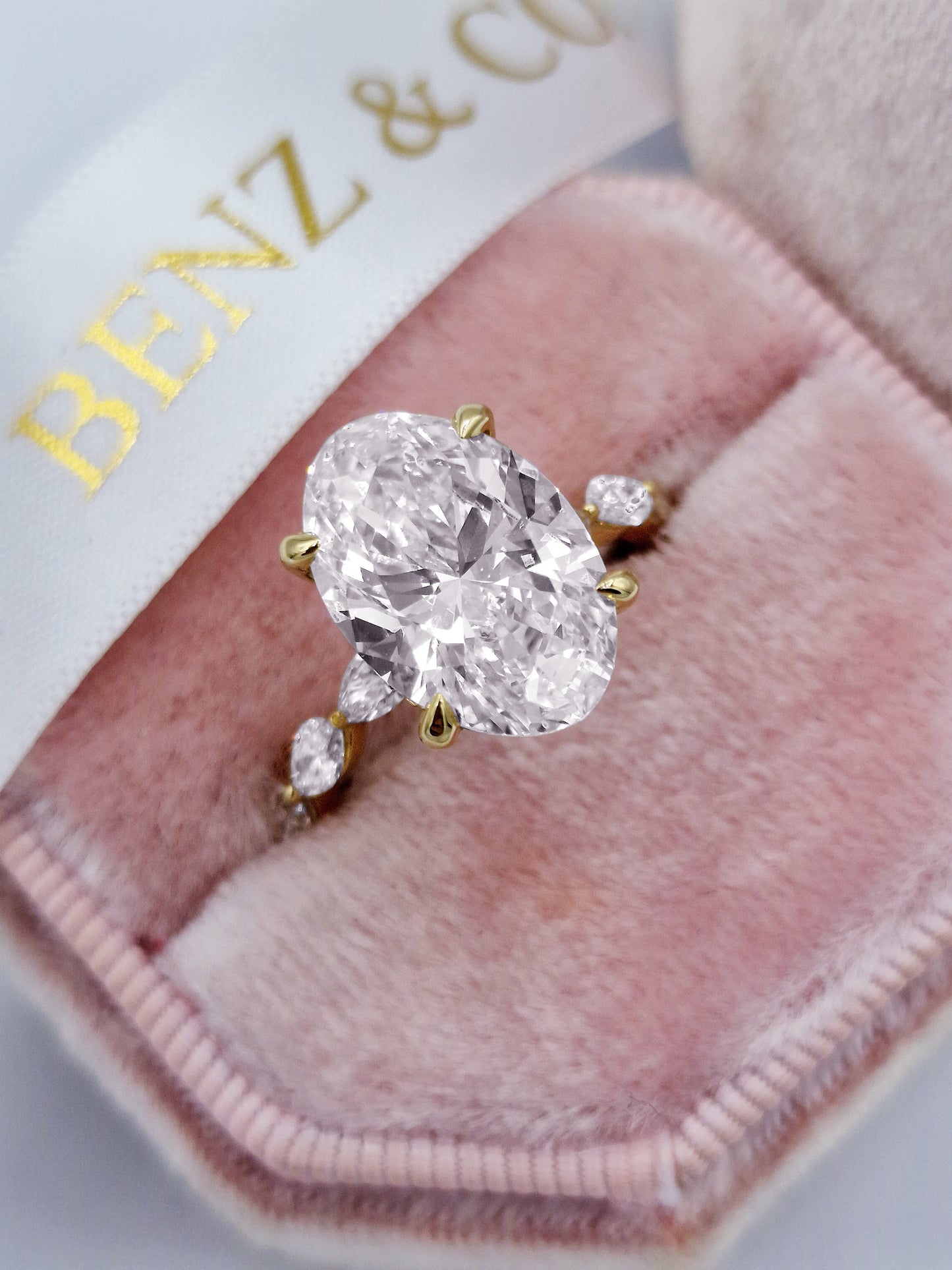 Oval 5ct diamond engagement ring with marquise accents in yellow gold