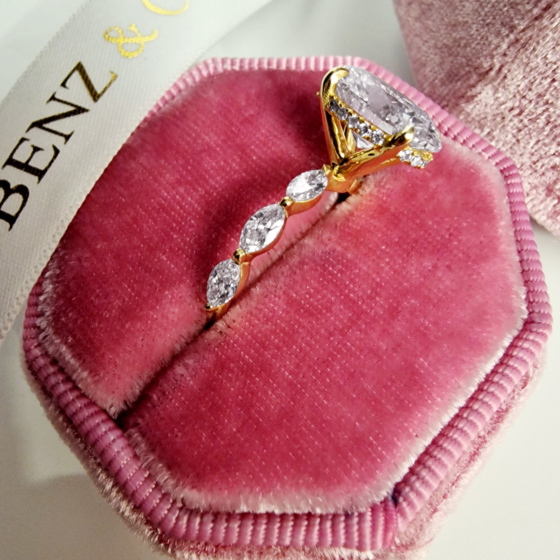 Oval diamond engagement ring with marquise band and yellow gold