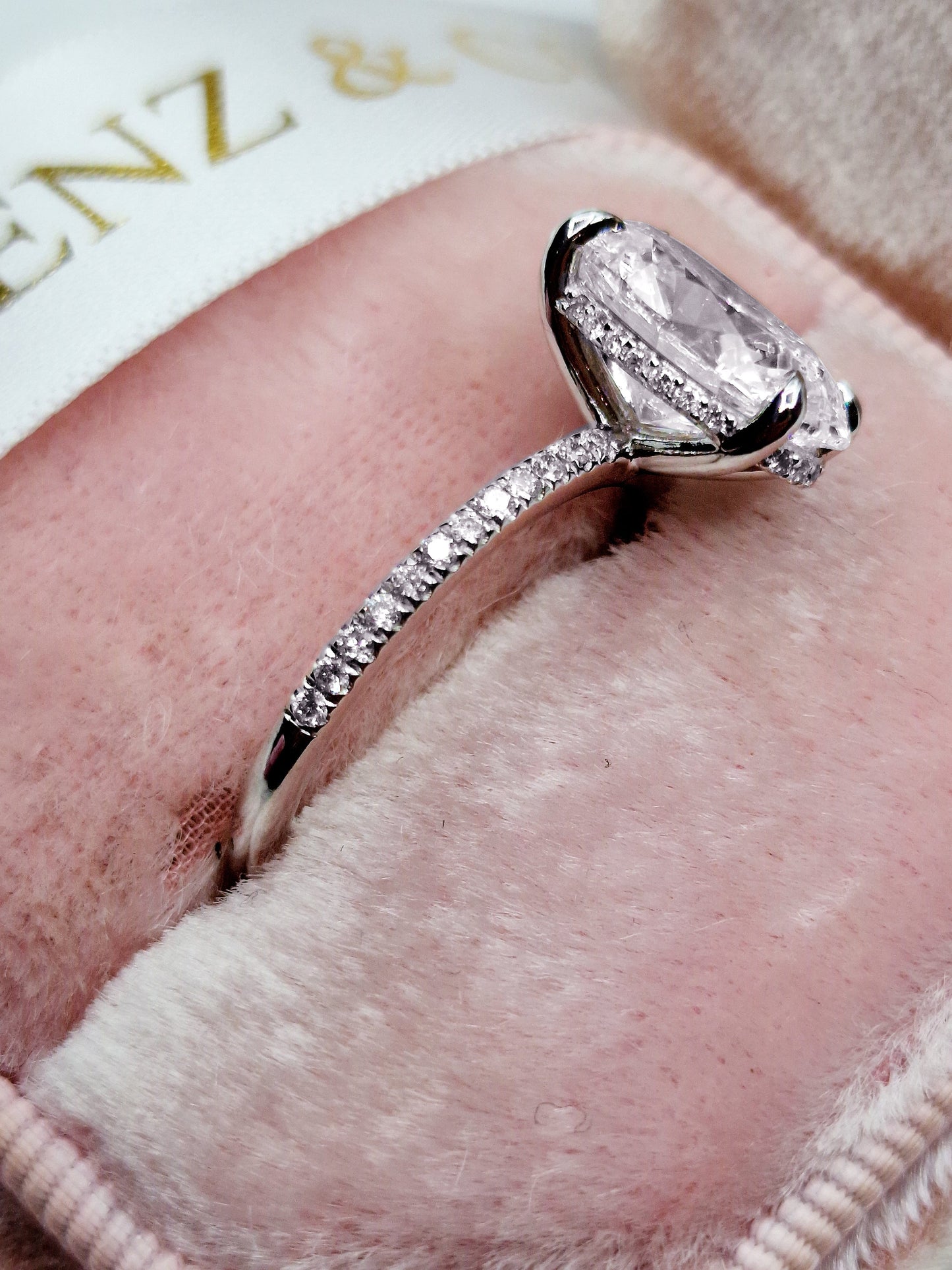 Oval cut 3ct lab grown diamond engagement ring, hidden halo, side view.