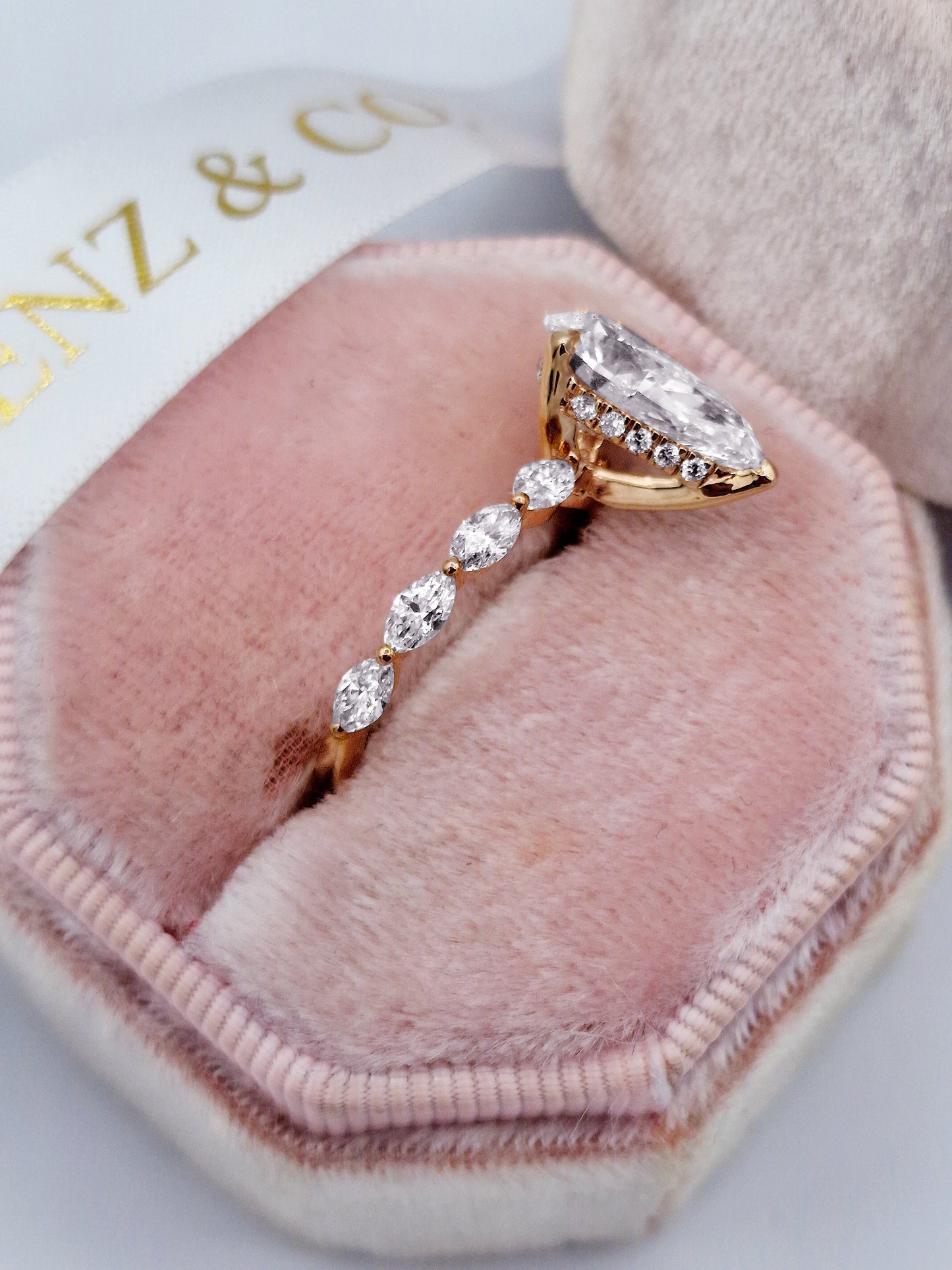 Rose gold pear diamond engagement ring with marquise side stones