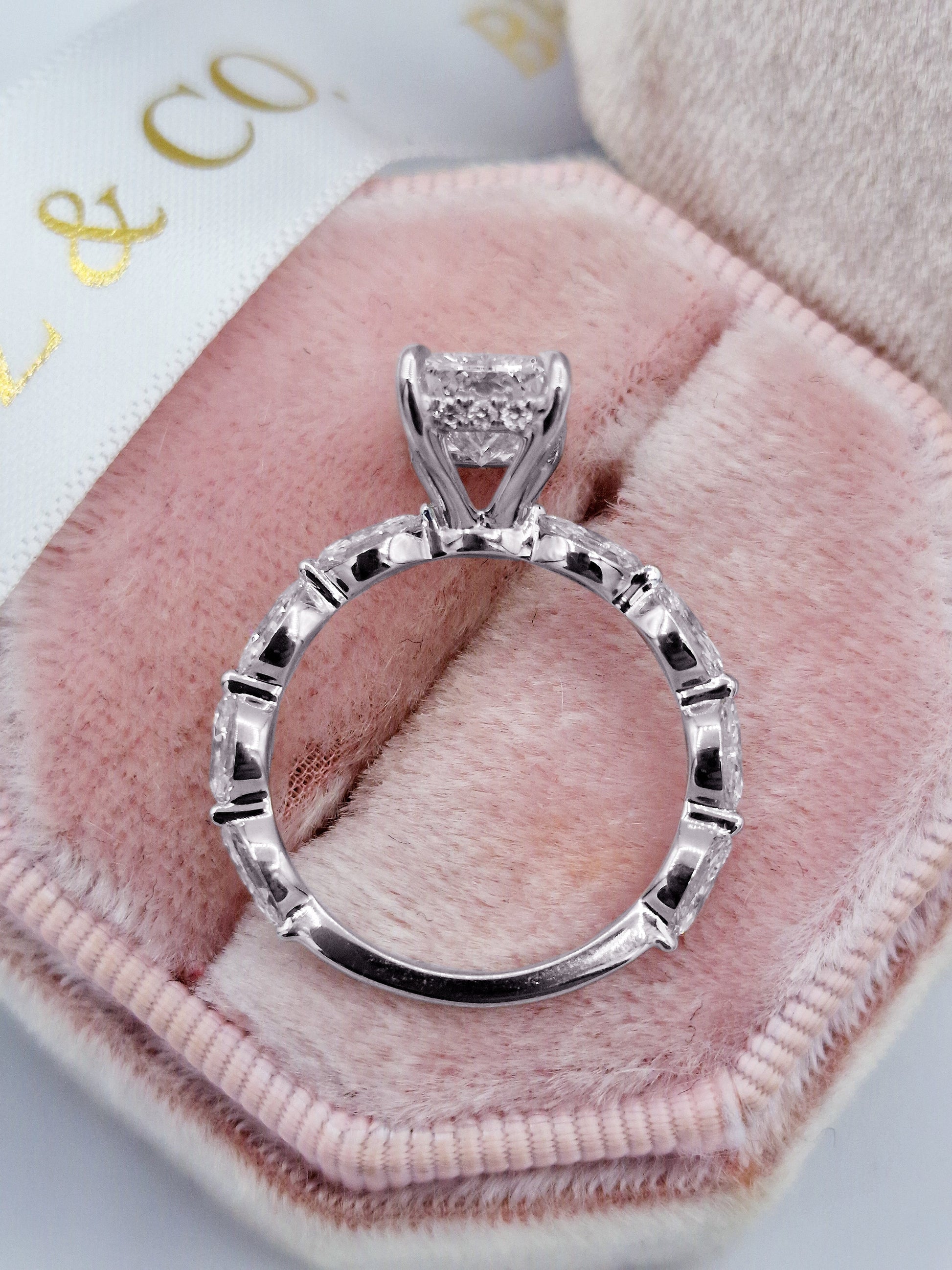 Radiant diamond engagement ring with marquise side stones.