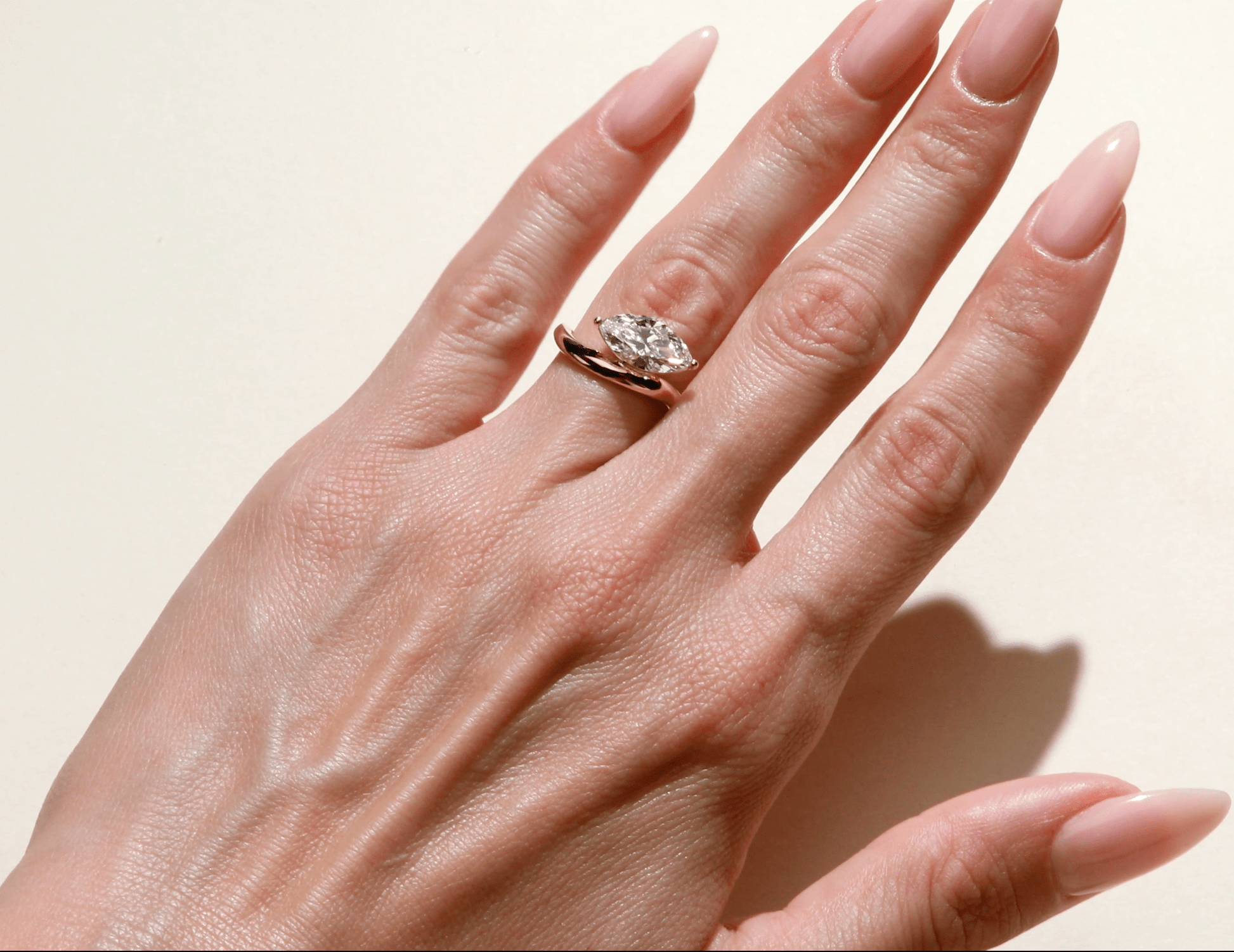 Wave marquise diamond engagement ring on hand