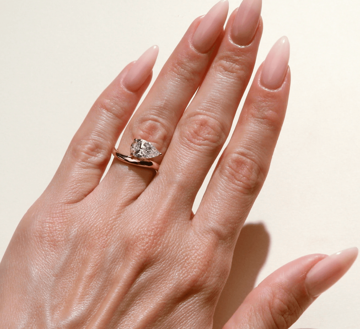 Yellow gold shaped diamond solitaire engagement ring on hand