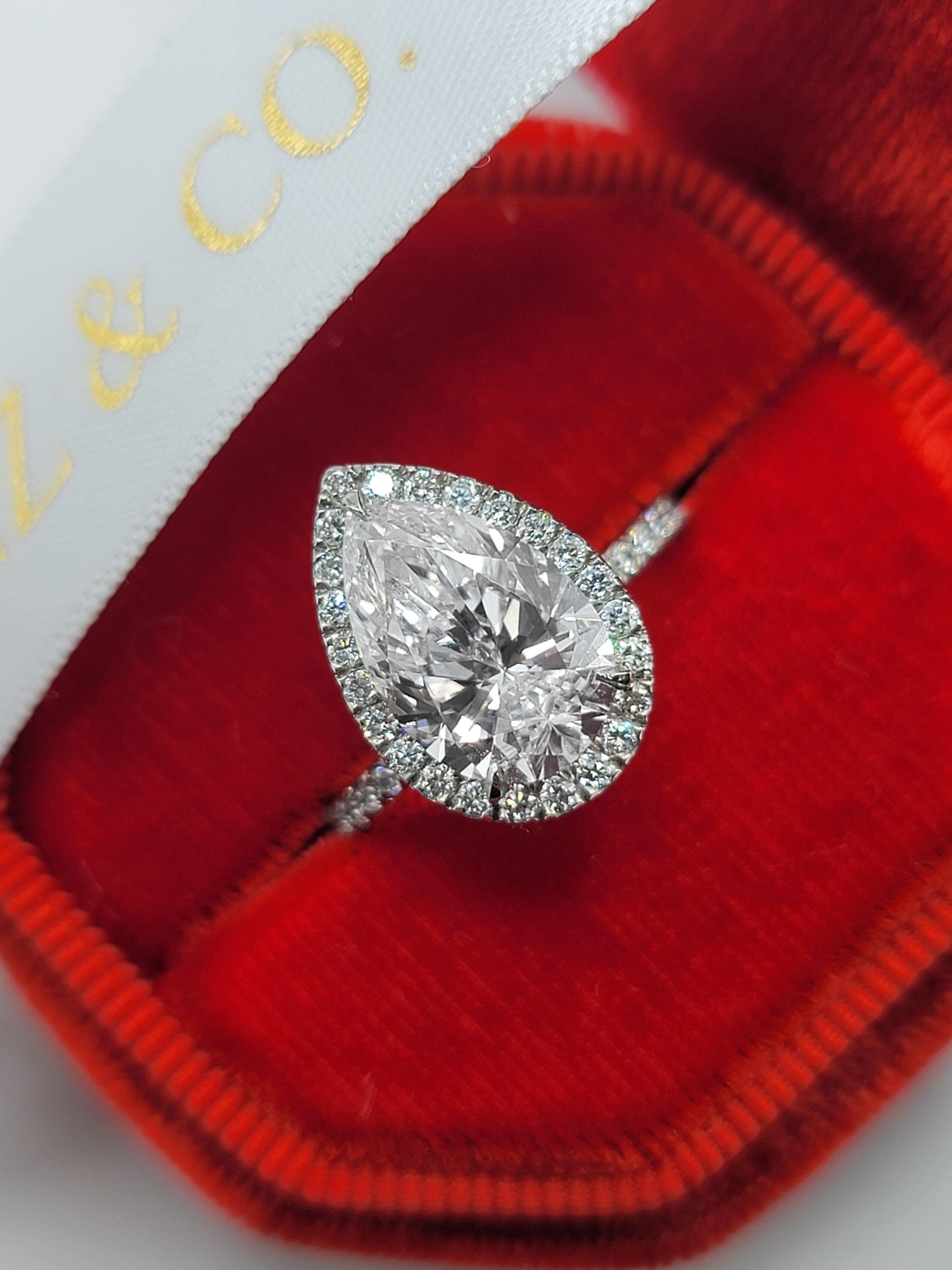 Pear-shaped diamond ring in a red velvet box.