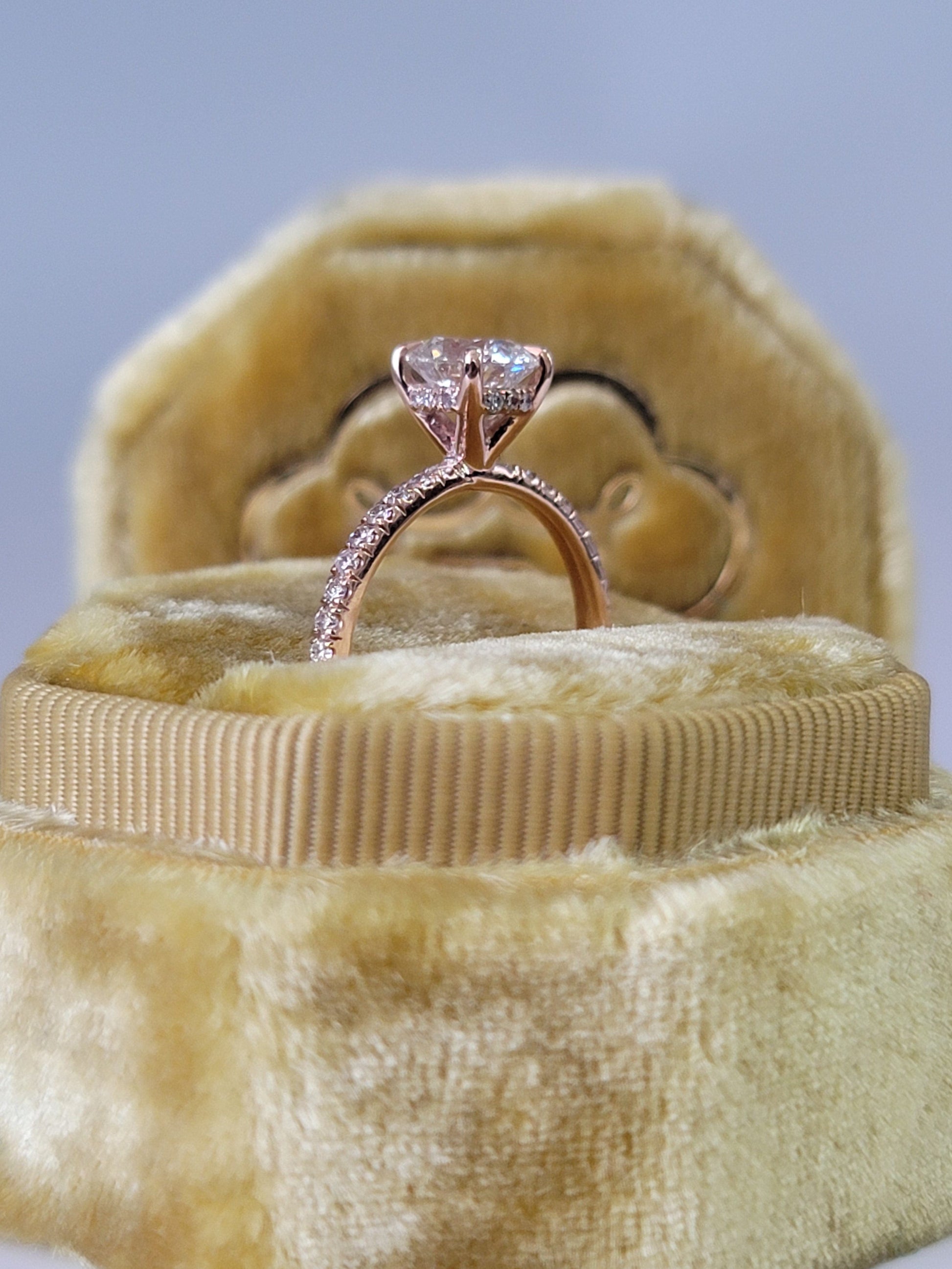 Rose gold engagement ring in velvet box.
