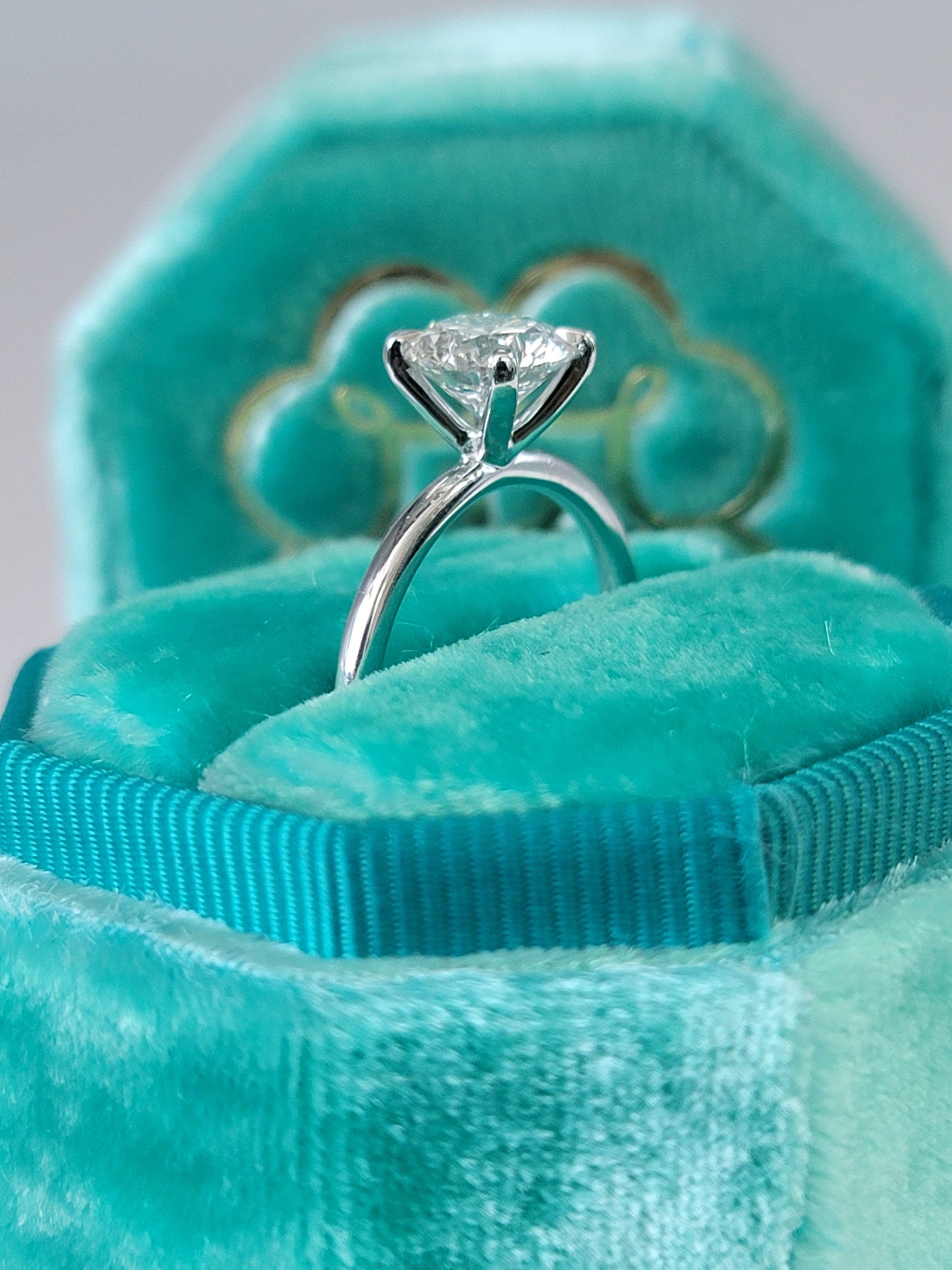 Diamond ring in a teal velvet box.