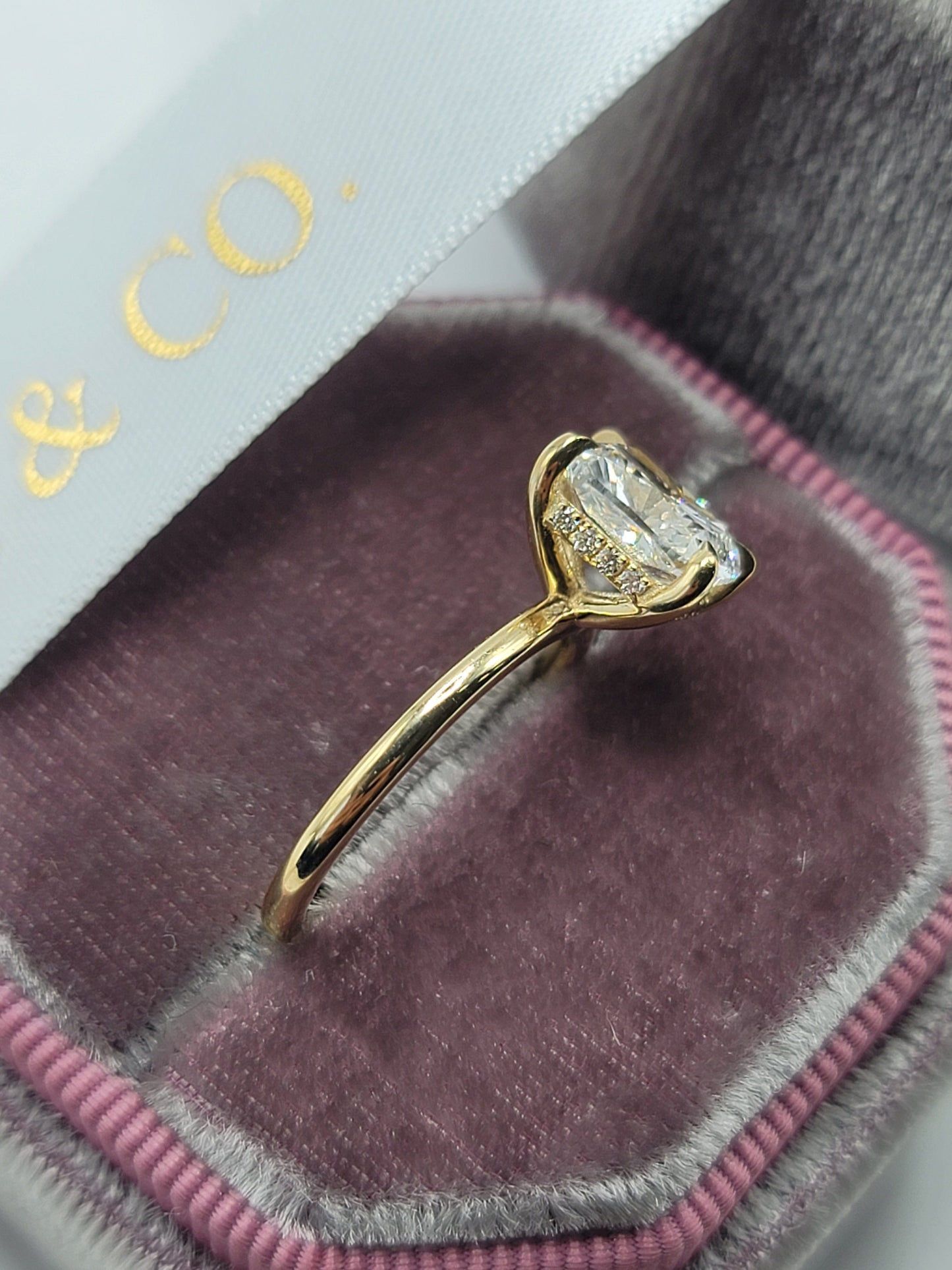 Gold ring with large diamond in a velvet box.