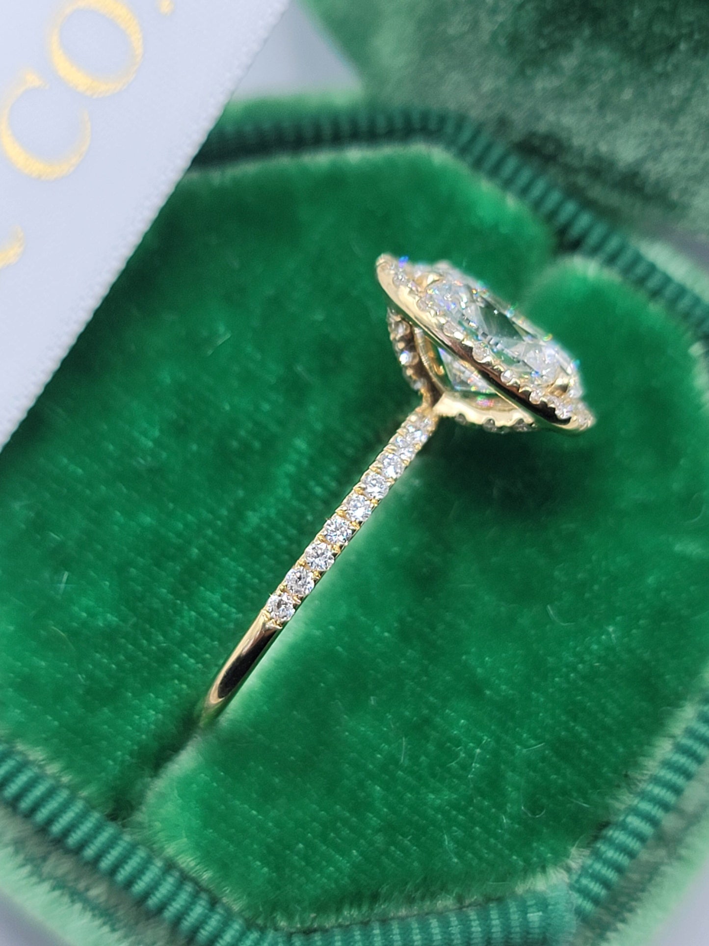 Diamond engagement ring in a green velvet box.