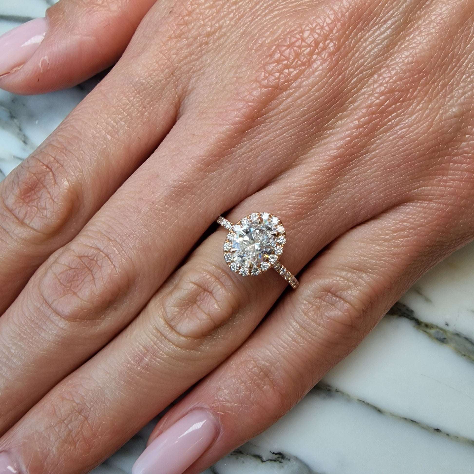 Hand with diamond engagement ring.
