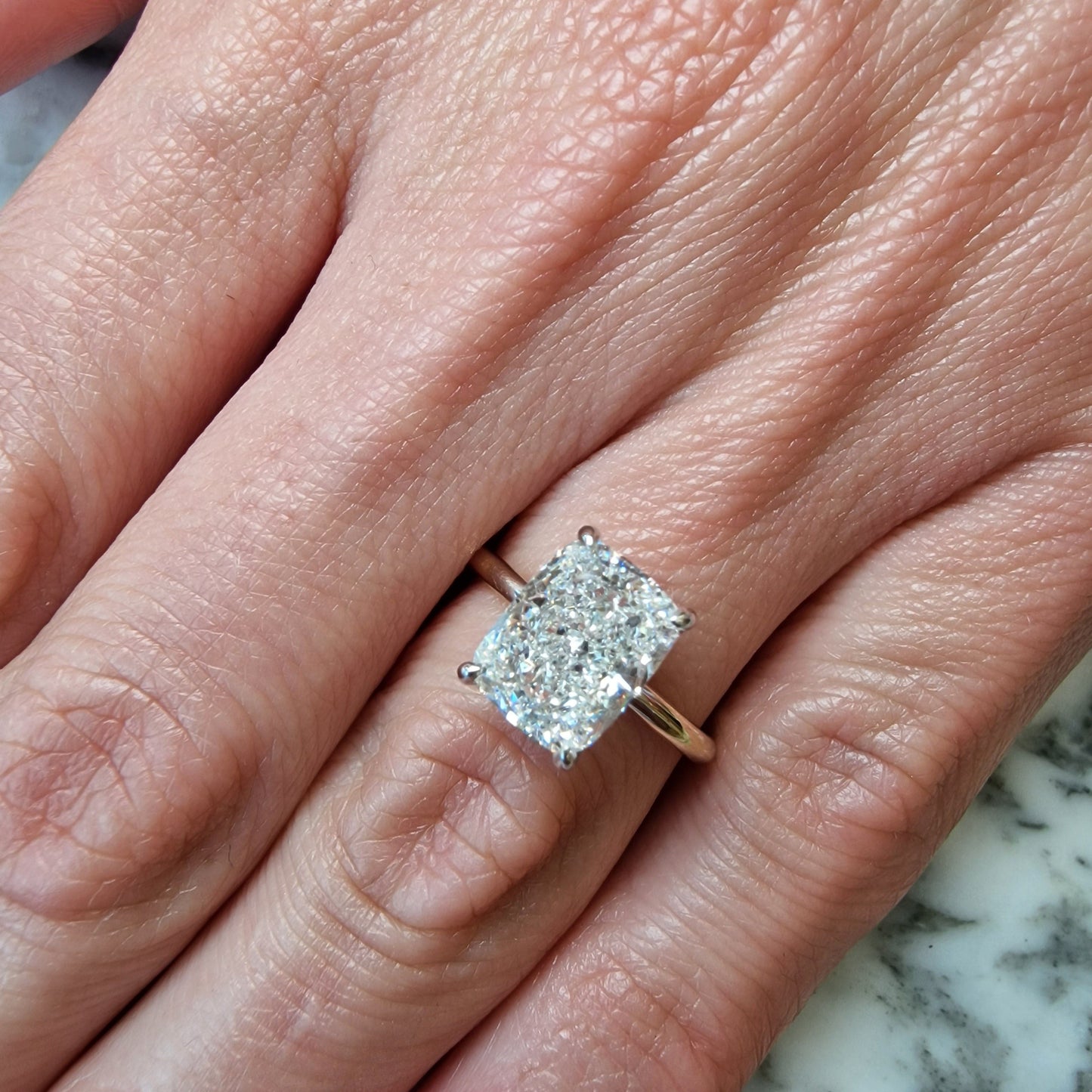 Hand with a large rectangular diamond ring.