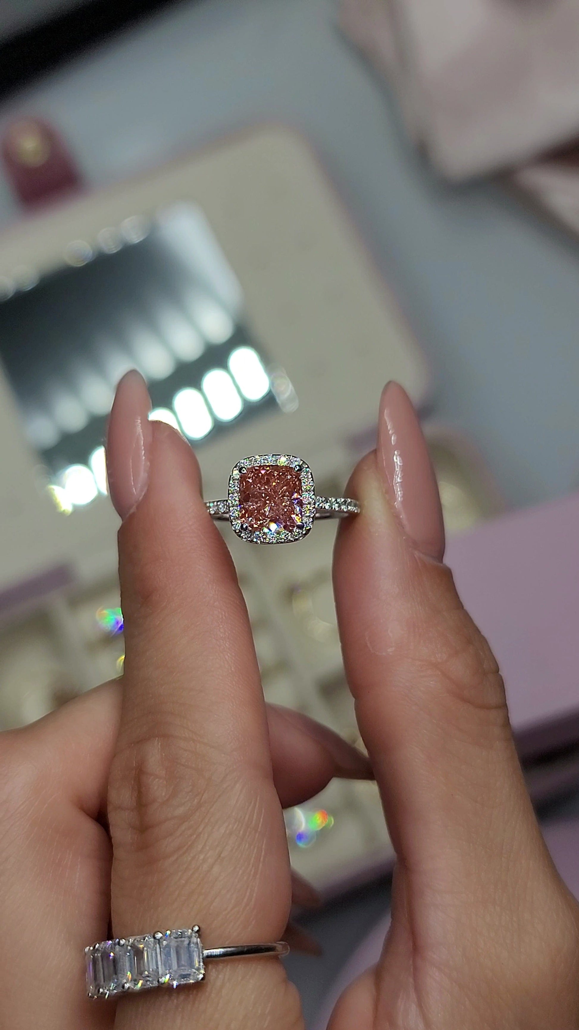 Woman holding a pink diamond ring, captured 2023-01-29.
